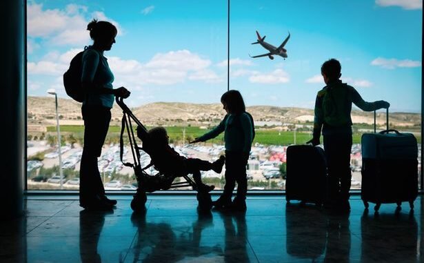 0_mother-with-kids-and-luggage-looking-at-planes-in-airport.jpg